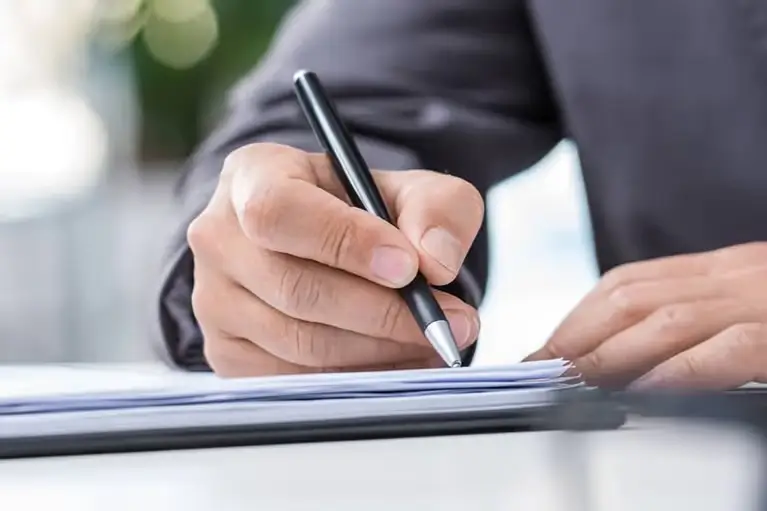 man-signs-papers-in-well-lit-room-mobile