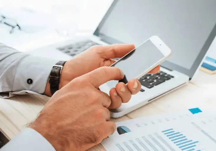 man-calculates-finances-with-smartphone-mobile